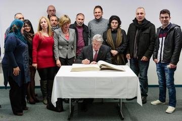 Bundespräsident Joachim Gauck trägt sich in die Lagerchronik des Grenzdurchgangslagers Friedland ein.