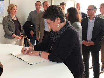 Die Vorsitzende der Fraktion von Bündnis 90/Die Grünen Anja Piel trägt sich in das Gästebuch des Museums Friedland ein