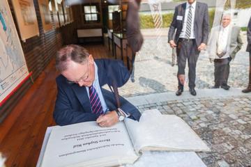 Der Niedersächsische Ministerpräsident Stephan Weil trägt sich in die Friedlandchronik ein. Die Chronik dokumentiert seit Jahrzehnten die Geschichte des Grenzdurchgangslagers Friedland