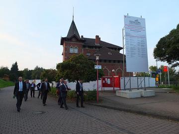 Besuchergruppe um BA Hartmut Koschyk MdB vor dem historischen Bahnhofsgebäude (1. Bauabschnitt des Museums Friedland)