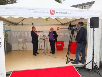 Redakteur Hans-Heinrich Obuch interviewt Ministerpräsident Stephan Weil im Medienzentrum des Gemeinschaftszeltes "Willkommens- und Erinnerungskultur"